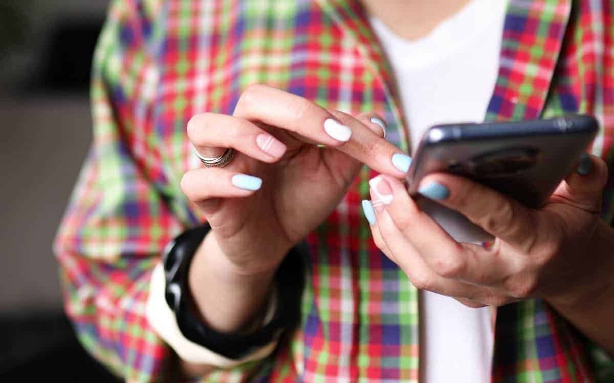 Hand som scrollar på en mobiltelefon.