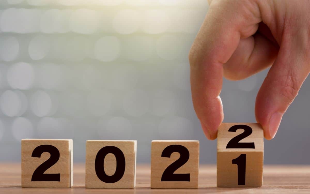 En hand vänder på klossarna med siffrorna 2021 så att det istället står 2022.